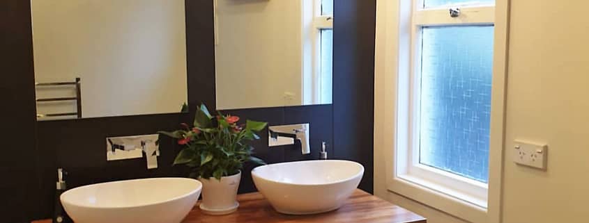 Double sink, shelves & mirrors in a bathroom built & designed by Brewer Builders