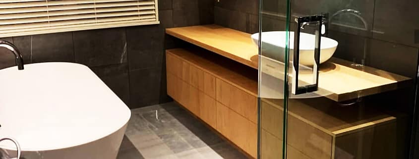 Wash basin, bath tub & mirror in a bathroom built & designed by Brewer Builders